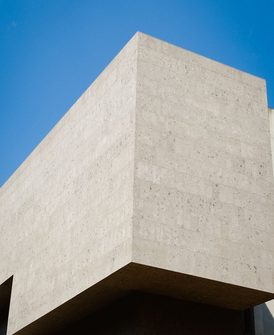Concrete building volume cantilevered against a deep blue sky