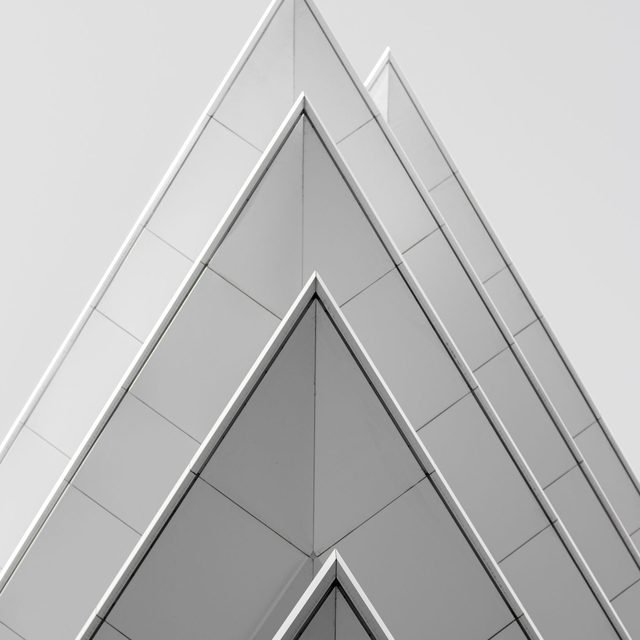 White chevron roof structure against a pale sky